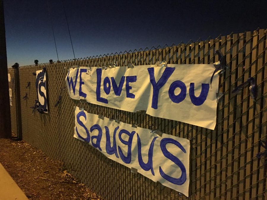 These posters, along with hundreds of blue and white glow sticks, lined the fences along the street from Saugus High School all the way to Central Park on the night of the vigil.