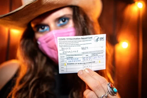 Molly Moore shows off her vaccine card, which allowed her to gain entry into Permanent Records Roadhouse in Cypress Park.