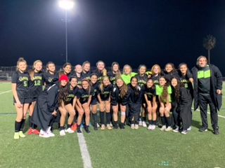 Girls soccer takes a team photo after a hard-fought game.