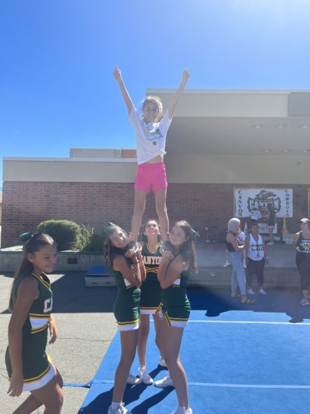 Last year’s youth clinic girls stunting with one of the future cheerleaders!!