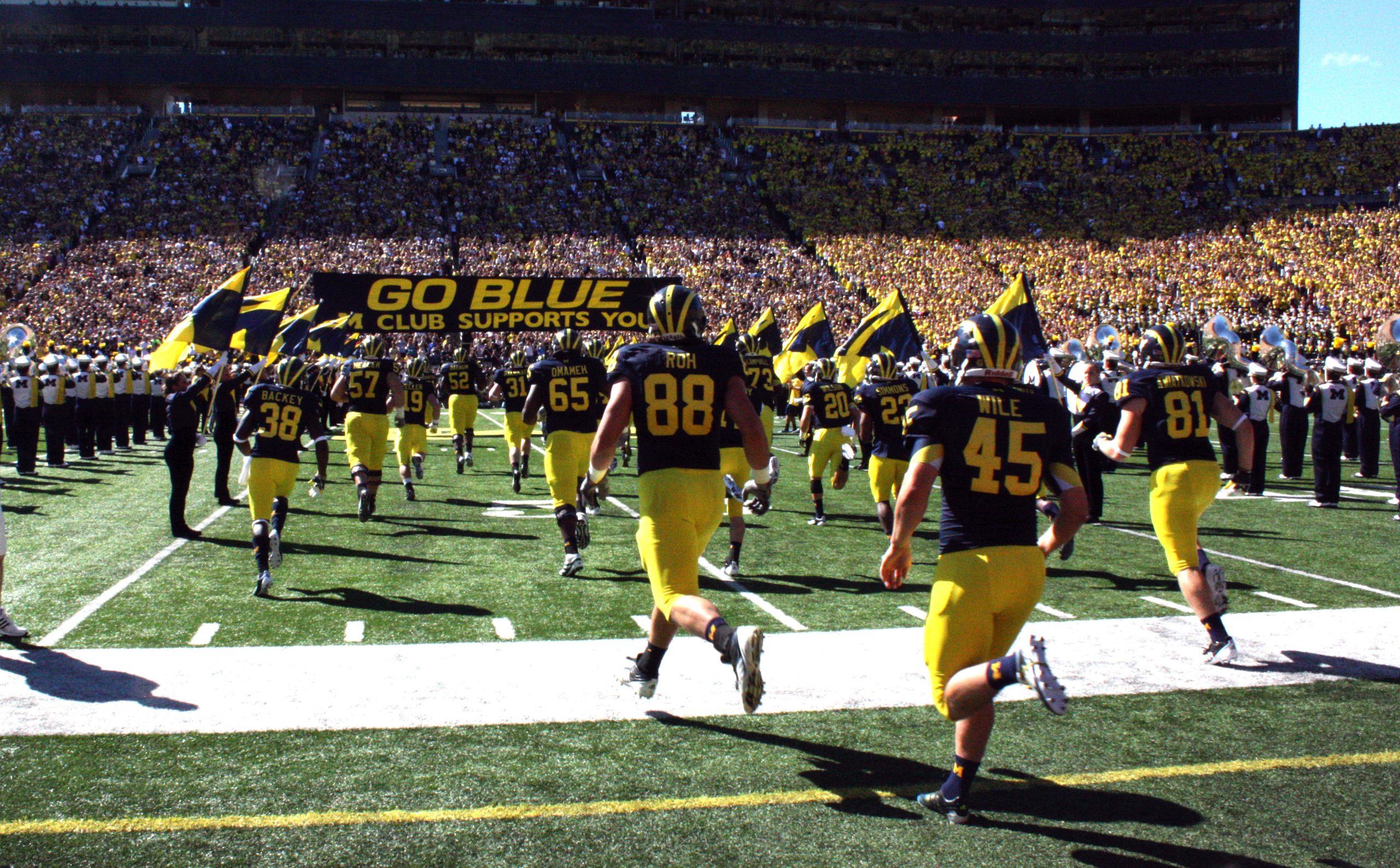 The Michigan Wolverines football team running onto the field before the game.
