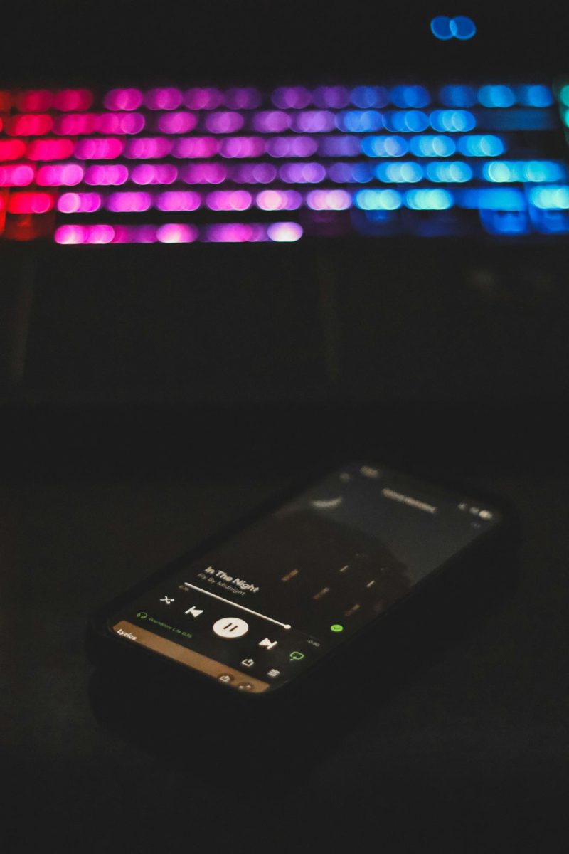 An iPhone 13 mini playing music from Spotify.