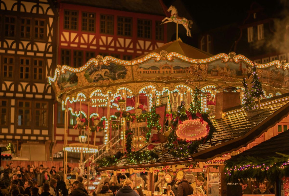 The Frankfurt Christmas Market in Germany with a carousel in the background and holiday decorations